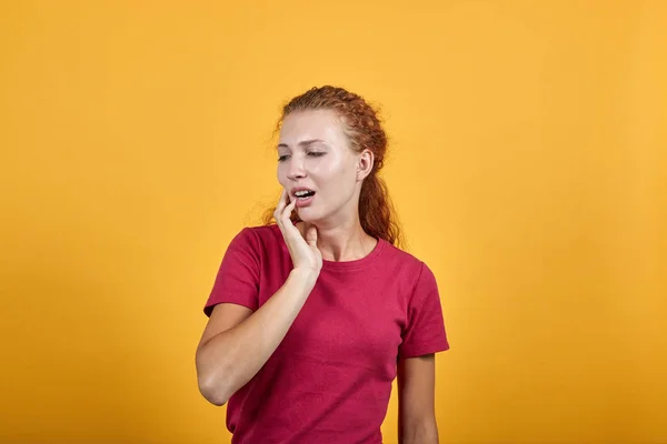 Привлекательная юная леди в красной рубашке держит руку на губах, зубная боль — стоковое фото