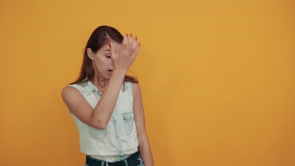 Mujer joven caucásica confusa manteniendo la mano en la cabeza, mirando confundido — Vídeos de Stock