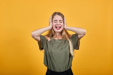 Rahat elbiseli bir kadın gözlerini kapalı, elleri başının arkasında tutuyor.