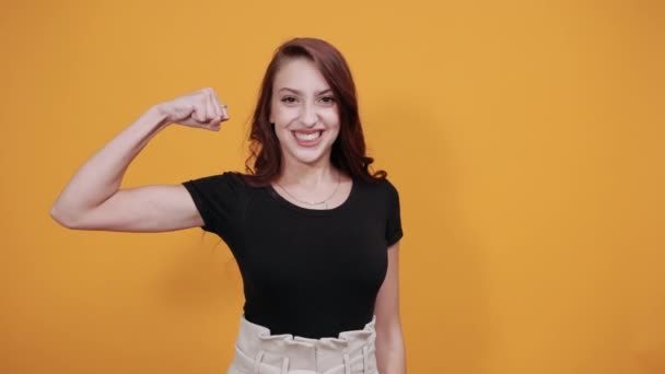 Blank meisje het vasthouden van handen, pronken haar spieren het dragen van casual zwart shirt — Stockvideo