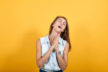 Mavi kot gömlekli çekici bir kadın dua ediyor, el ele tutuşuyor.