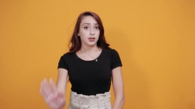 Siyah tişörtlü ciddi bir kadın, duraksamadan hareket ediyor, hayal kırıklığına uğramadan.