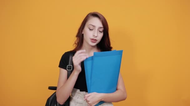 Mujer atractiva manteniendo carpeta azul, cogida de la mano en la cabeza, dolor de cabeza — Vídeo de stock