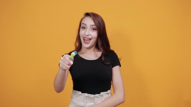Mulher bonita em camisa preta, segurando escova de dentes perto da boca, sorrindo — Vídeo de Stock