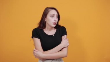 Donmuş genç bir kadın ellerini çapraz tutuyor, kendine sarılıyor, ısınmaya çalışıyor.