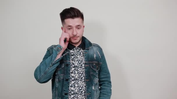Jonge knappe man in fashion shirt houden handen op de wangen, op zoek direct — Stockvideo