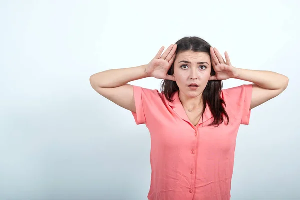 Atractiva joven mujer cogida de la mano en la cabeza, mirando asustada . — Foto de Stock