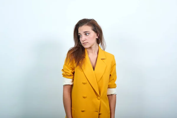 Tråkig kvinna i gul jacka dyker upp, besviken och missnöjd — Stockfoto