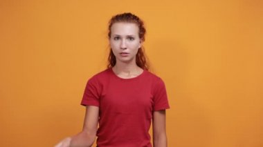 Kırmızı gömlekli kadın, elinde gözü, üzgün görünüyor.