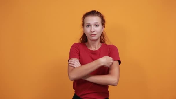 Glimlachende jongedame in rood shirt die handen gekruist houdt, lacht — Stockvideo