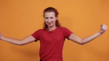 Kırmızı gömlekli güzel bayan kaslarını gösteriyor, mutlu görünüyor.