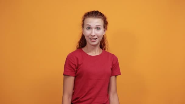 Bonita joven con camisa roja extiende la mano en saludo — Vídeos de Stock