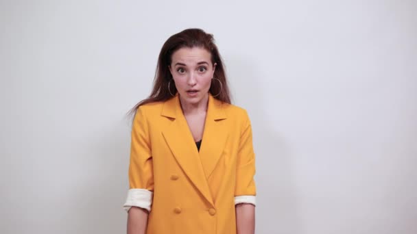 Jovem caucasiano mulher atraente em casaco amarelo mantendo polegares diretamente — Vídeo de Stock