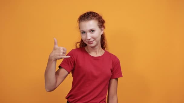 Mujer divertida haciendo gesto de teléfono celular, hablando, señalando directamente — Vídeos de Stock