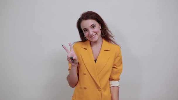 Веселая молодая женщина показывает победный жест — стоковое видео