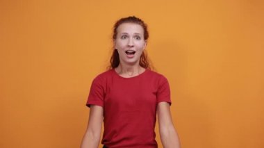 Kırmızı gömlekli güzel bir bayan kazanan jest yapıyor, gülümsüyor, yumruklarını havada tutuyor.