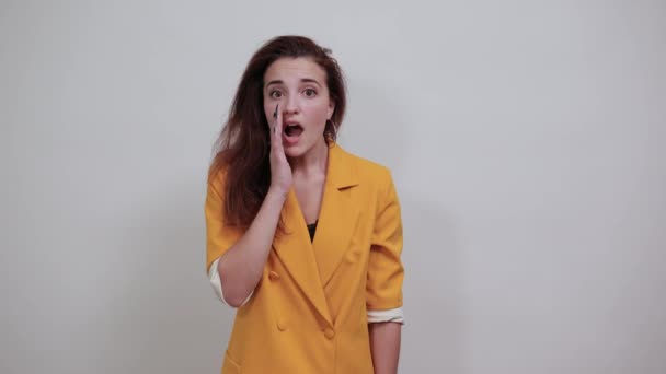 Elbűvölő nő tartja a kezét a száján, bejelentve és kiabálva — Stock videók