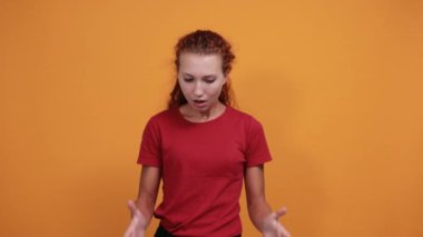 Çekici bir kadın bir şey söylüyor ve konuşuyor, ellerini açıyor.