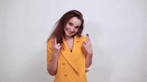 Glada ung kvinna i gul jacka tittar direkt, pekar på avstånd — Stockvideo