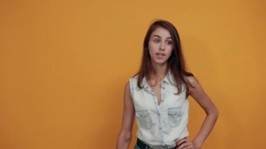 Attractive brunette woman winks, showing victory gesture.