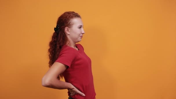 Bonita joven con camisa roja estira la espalda — Vídeos de Stock