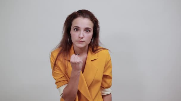 Привлекательная молодая женщина выглядит злой, держа кулак угрожающе — стоковое видео