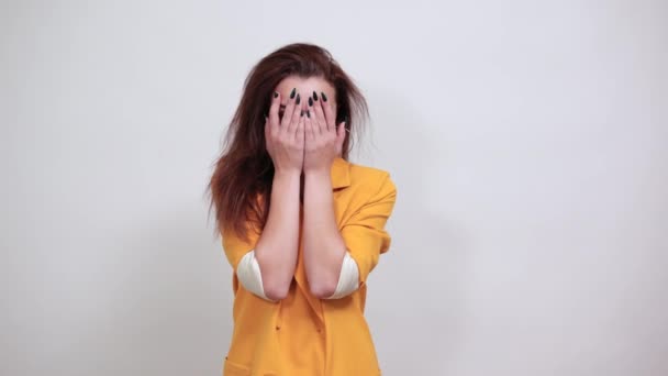 Vonzó nő eltakarja a szemét, átnéz a kezén — Stock videók