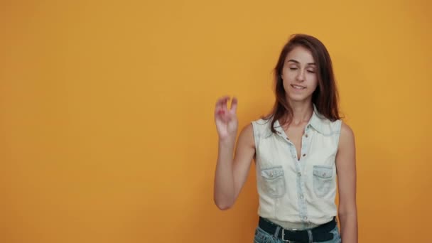 Сумасшедшая белая молодая женщина в синей джинсовой рубашке показывает девять пальцев — стоковое видео