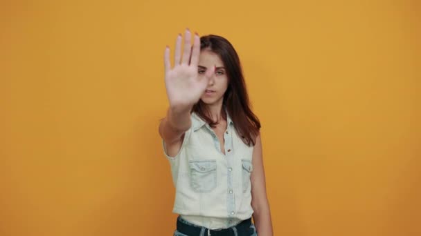 Attractive brunette caucasian young woman in blue denim shirt doing stop gesture — Stock Video