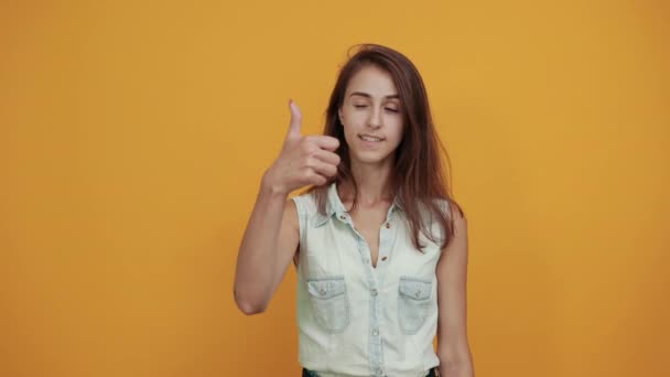 Engraçado caucasiano jovem mulher em camisa jeans azul mantendo os polegares para cima, sorrindo — Vídeo de Stock