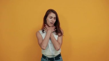 Ciddi bir beyaz kadın ellerini boynuna koyup kendini boğuyor.