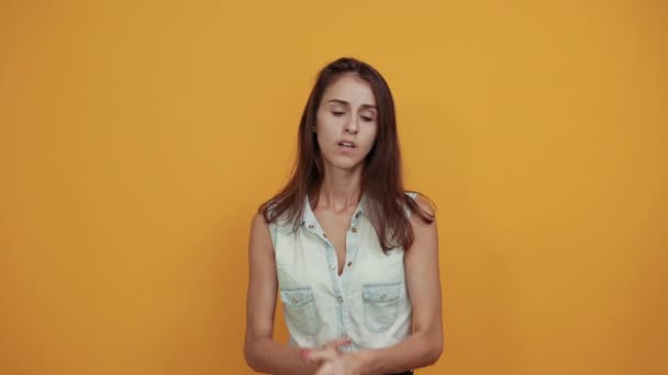 Pretty caucasian young woman in blue denim shirt keeping hand together, praying — Stock Video