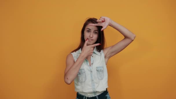 Wanita muda Kaukasia ceria melakukan frame dengan jari, tampak bahagia — Stok Video