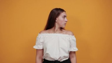 Çekici genç beyaz bayan parmağını ağzında tutuyor, sessiz jest yapıyor.