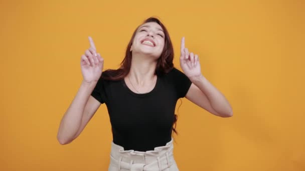 Портрет молодої жінки в приємному повсякденному одязі, що піднімається пальцями, як переможець — стокове відео