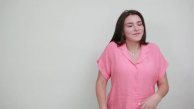 Çekici beyaz kadın dilini gösteriyor, komik görünüyor, saç kesimini düzeltiyor.