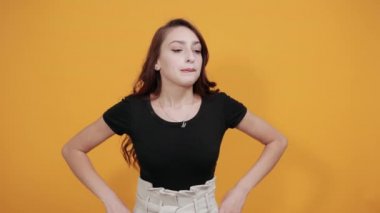 Çekici kadın kafası karışmış, sıkılmış, elini beline koyuyor.