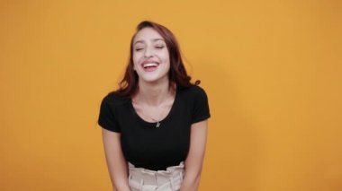 Siyah gömlekli çekici genç bir kadın işaret ediyor, dil gösteriyor.