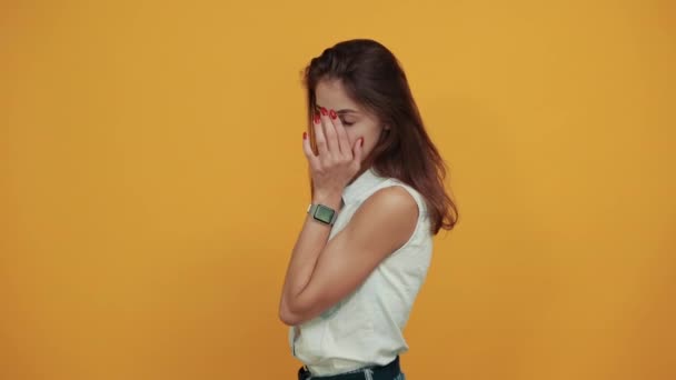 Cansado caucasiano jovem mulher em camisa jeans azul mantendo a mão na cabeça, dor de cabeça — Vídeo de Stock