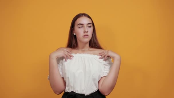 Tired young woman keeping hand on head, headache isolated on orange wall — Stock Video