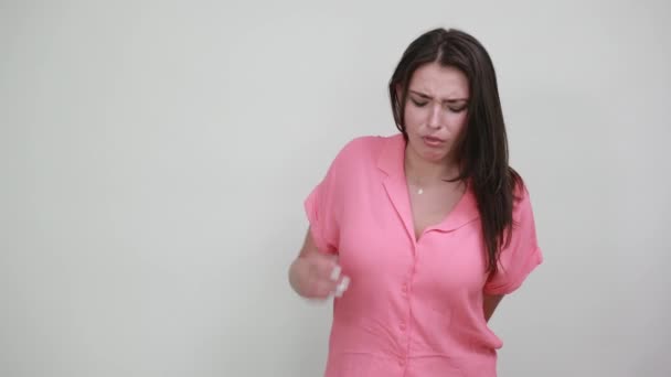Розчарована біла молода жінка в рожевій сорочці виглядає втомленою, незадоволеною — стокове відео