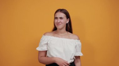 Çekici genç bir kadın, elini kulaklarına uzatıyor, saçlarını dalgalandırıyor.