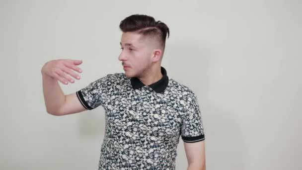 Молодой красивый мужчина в модной рубашке указывает на расстояние — стоковое видео