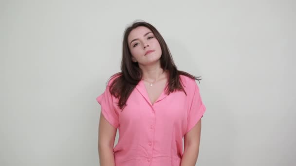 Mujer seria manteniendo los dedos bajo los ojos, limpia las lágrimas en la camisa rosa casual — Vídeos de Stock