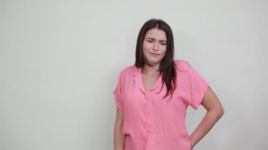 Hayal kırıklığına uğramış genç bir kadın gri duvarda izole edilmiş jesti durduruyor.