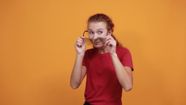 Jolie dame ayant des lunettes de soleil, gardant les mains derrière le dos, tête levée — Video