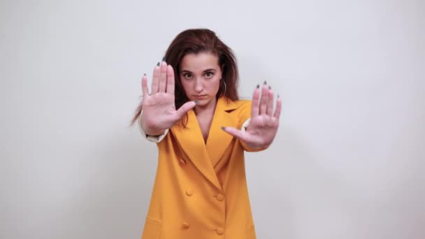Młoda kobieta w żółtej kurtce nie robi żadnego gestu, wygląda na nieszczęśliwą — Wideo stockowe