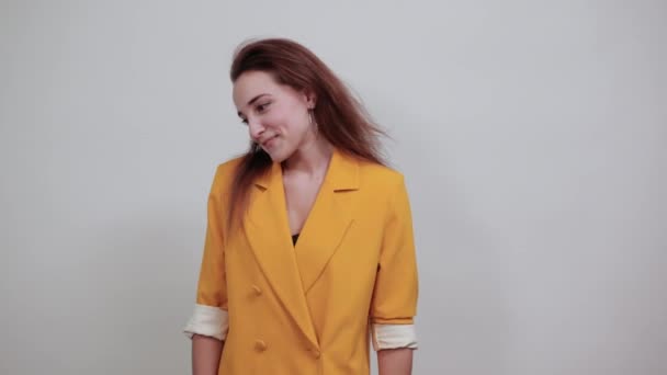 Attractive young lady in yellow jacket keeping hand on head, cheerful — Stock Video