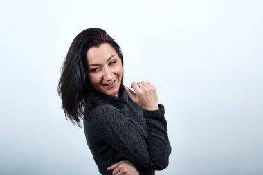 Beyaz kadın yan yatmış, elini karnına koyup gülümsüyor, mutlu görünüyor.