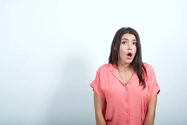 Attractive caucasian young woman in pink shirt shocked, keeping mouth opened — 스톡 사진